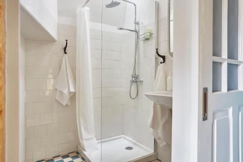 La salle de bains est pourvue d'une douche et d'un lavabo. dans l'établissement Fence Houses, à Coimbra