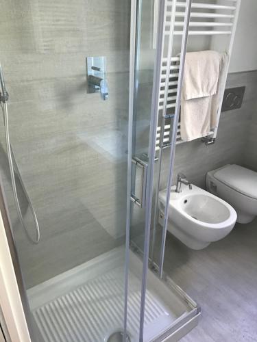 y baño con ducha, aseo y lavamanos. en Stunning Apartment 300mt from the beach, en Forte dei Marmi