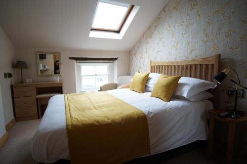 a bedroom with a large white bed with yellow pillows at Croft Guesthouse in Cockermouth