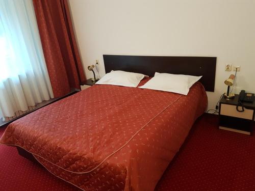 a bedroom with a red bed with two pillows at Cristal Sinaia in Sinaia