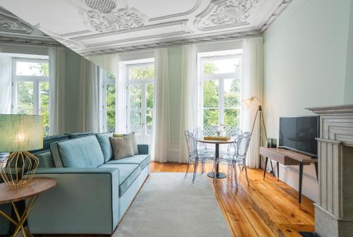 a living room with a blue couch and a table at Predicados do Douro Palace in Porto