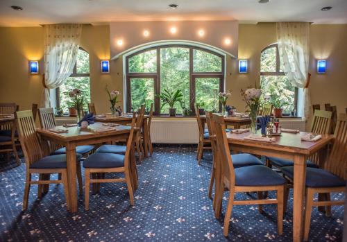 a restaurant with wooden tables and chairs and a window at Hotel Marami in Sinaia