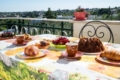 un tavolo con pane, prodotti da forno e tazze di caffè di B&B Casa Mariangi a Castellana Grotte