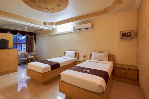 Habitación de hotel con 2 camas y TV en Hotel Swan Inn, en Pune