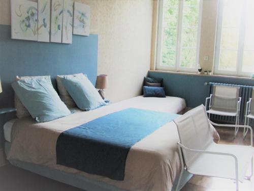 een slaapkamer met een bed met blauwe muren en ramen bij chambre d'hôtes du Valvion in Beauquesne