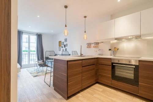 une cuisine avec des armoires en bois et un comptoir dans l'établissement Le Semiramis, à Saint-Tropez