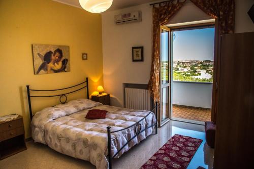 a bedroom with a bed and a large window at B&B Casa Mariangi in Castellana Grotte