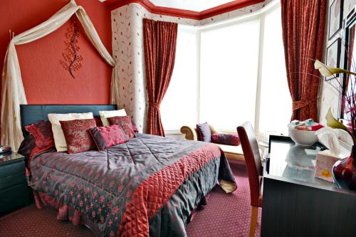 ブラックプールにあるThe Astor Hotelのベッドルーム1室(赤い壁のベッド1台、窓付)