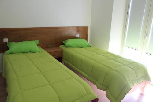 two beds with green covers in a room at Turismo Rural Pão e Água in Mértola
