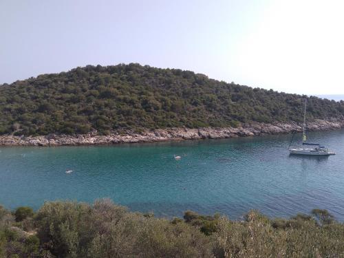 a boat in a body of water with an island at Manti in Skala Marion