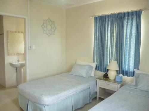 Habitación de hotel con 2 camas y lavamanos en A Home Away from Home en Saint Michael