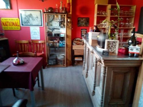 a red room with a counter and a table in it at Le Relais du Moulin in Gedinne