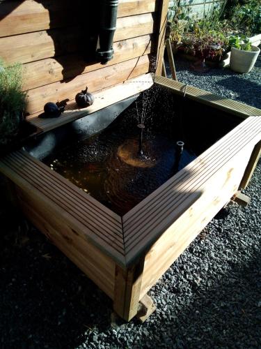 a wooden bird house with a pond in it at Le Relais du Moulin in Gedinne