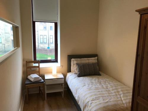 グラスゴーにあるThe Muranoの小さなベッドルーム(ベッド1台、ナイトスタンド、窓付)