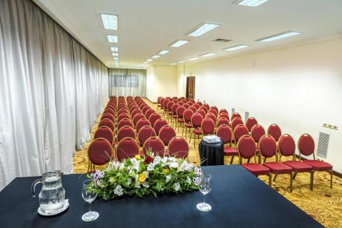 a conference room with red chairs and a table with flowers at Radisson Montevideo Victoria Plaza Hotel in Montevideo