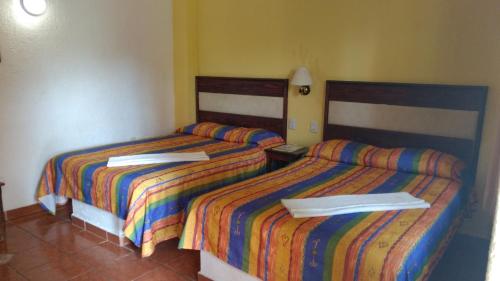 - deux lits assis l'un à côté de l'autre dans une pièce dans l'établissement Real del Ambar, à Tuxtla Gutiérrez