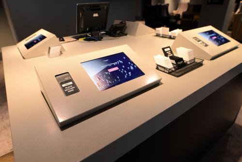 a white table with a tablet and other electronics on it at Village Hotel Maidstone in Maidstone