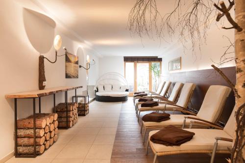 a room with a row of couches and a fireplace at Pöder - daheim in den Bergen in Ultimo