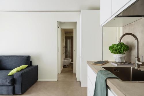 a kitchen with a sink and a blue chair at Palermo Flexyrent Apartment in Milan