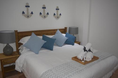 a bedroom with a bed with blue and white pillows at Beach Retreat Guesthouse in Amanzimtoti