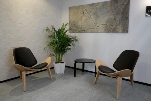 two chairs and a table in a room with a plant at MD Design Hotel - Portal del Real in Valencia
