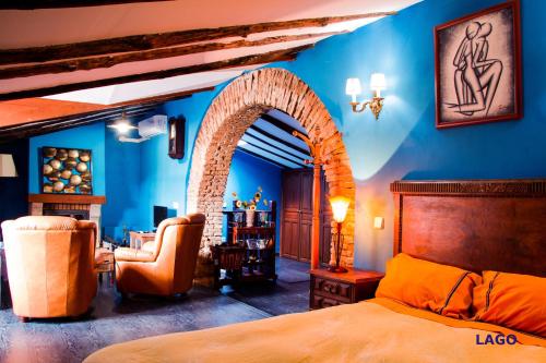 1 dormitorio con cama y pared azul en Casa Gibranzos, en Plasenzuela