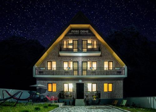 a large building with a balcony at night at OISHE Boutique Hotel in Stepantsminda