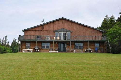 a large wooden barn with two benches in front of it at Powley's Wild Goose Lodge in Stanley Bridge
