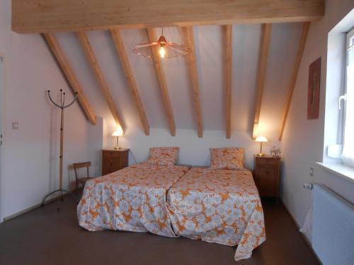 ein Schlafzimmer mit einem Bett in einem Zimmer mit Holzdecken in der Unterkunft Le Haut de l'Espérance in Uffholtz