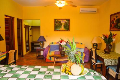 a living room with a table with a bowl of fruit at Hotel Casamar Suites in Puerto Escondido