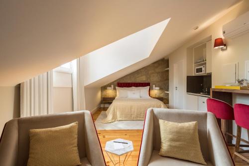a bedroom with a bed and two chairs at Predicados do Douro Palace in Porto