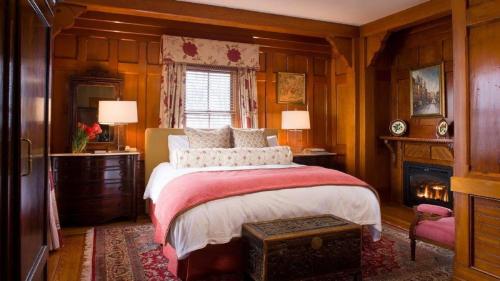 a bedroom with a bed with wooden walls and a fireplace at Castle Hill Inn in Newport