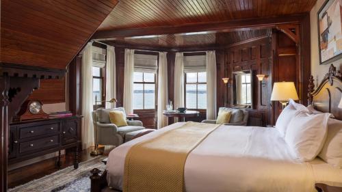 a bedroom with a large bed in a room with windows at Castle Hill Inn in Newport