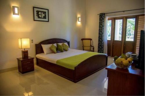 una camera con letto e tavolo con lampada di Coco Villa Peach Tree a Katunayake
