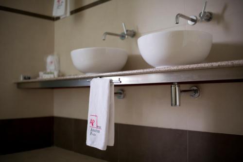 a bathroom with two sinks and two towels on a shelf at Hotel Abastos Plaza in Mexico City