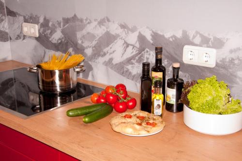 a cutting board with vegetables and wine bottles on a counter at Alp-Chalet in Hirschegg