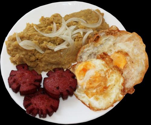 a plate of food with eggs and rice and meat at Hotel Caribe in Santa Cruz de Barahona