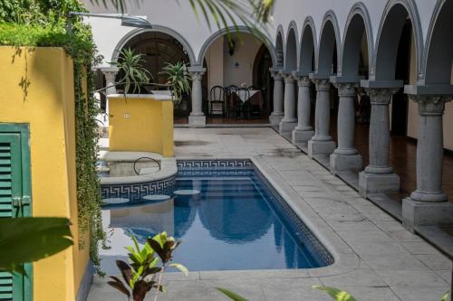 un patio con piscina en un edificio en Hotel Colonial, en San José