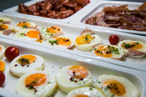 two white containers filled with deviled eggs and meat at Grid Hotel in Brno