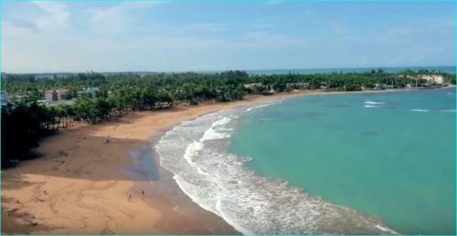 an aerial view of a beach with people on it at Beach front apartment in Luquillo in Luquillo