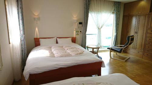 Säng eller sängar i ett rum på Shirahama Seaside Villa