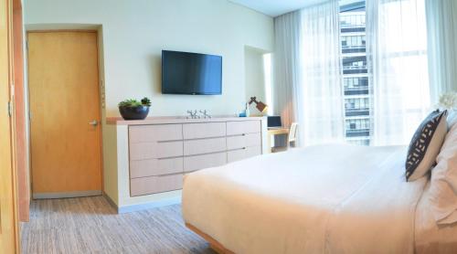 a bedroom with a bed and a tv on a dresser at Stadia Suites Mexico City Santa Fe in Mexico City