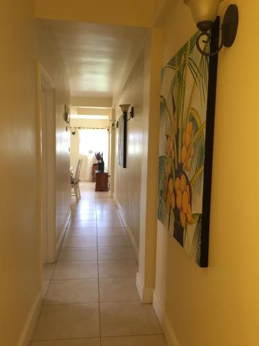 a hallway with a painting of fruit on the wall at South Sea House in Cap Estate