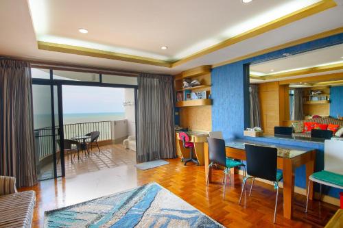 a living room with a table and chairs and a dining room at Cha am Beach Club in Phetchaburi