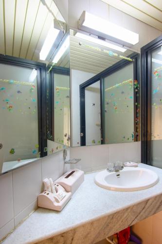 a bathroom with a sink and two mirrors at Cha am Beach Club in Phetchaburi