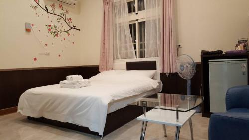 a bedroom with a bed and a chair and a table at Gajilia B&B in Chenggong