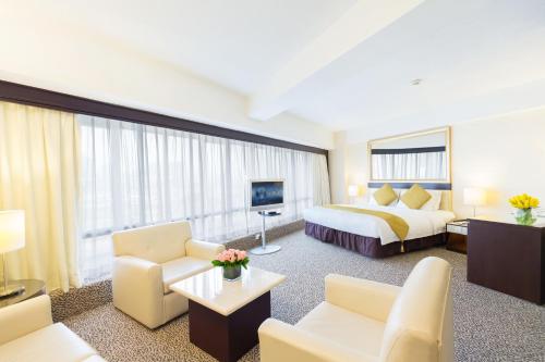 a hotel room with a king sized bed and a living room at Regal Oriental Hotel in Hong Kong