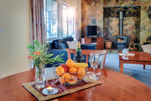 a table with a bowl of fruit and a bottle of wine at Waverley House Cottages in Lakes Entrance