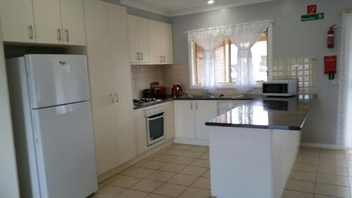 NumurkahNumurkah Self Contained Apartments - The Mieklejohn的厨房配有白色橱柜和白色冰箱