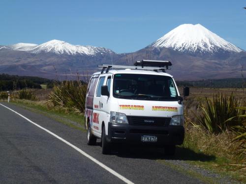 a van parked on the side of a road with a snow covered mountain at National Park Backpackers in National Park